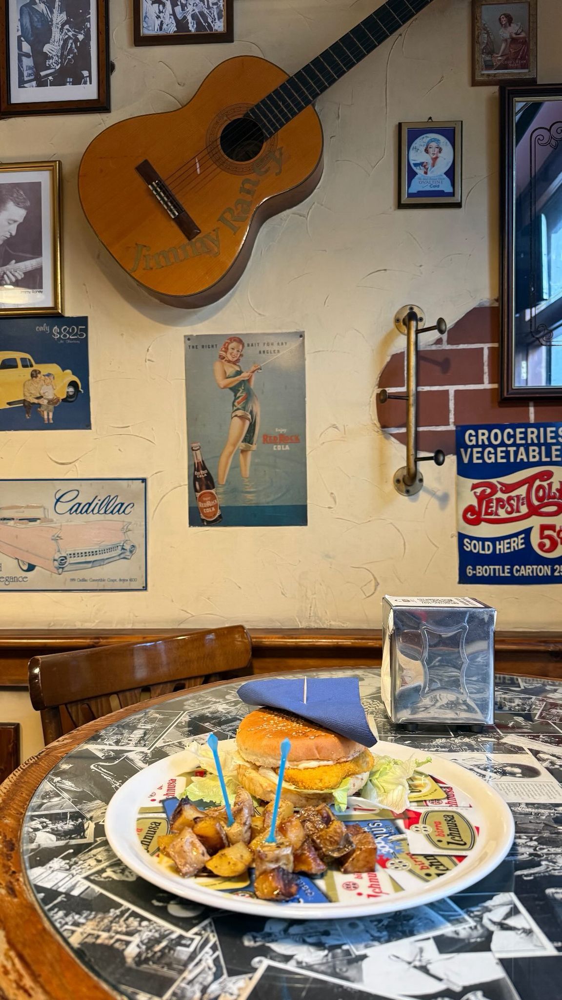 Panino con contorno servito ai tavoli dello Swing Pub, tra chitarra e stampe alle pareti
